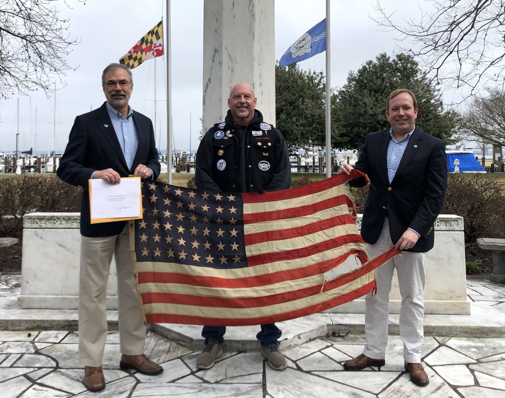 Harris, Carrier, and Bradshaw hold battle flag.